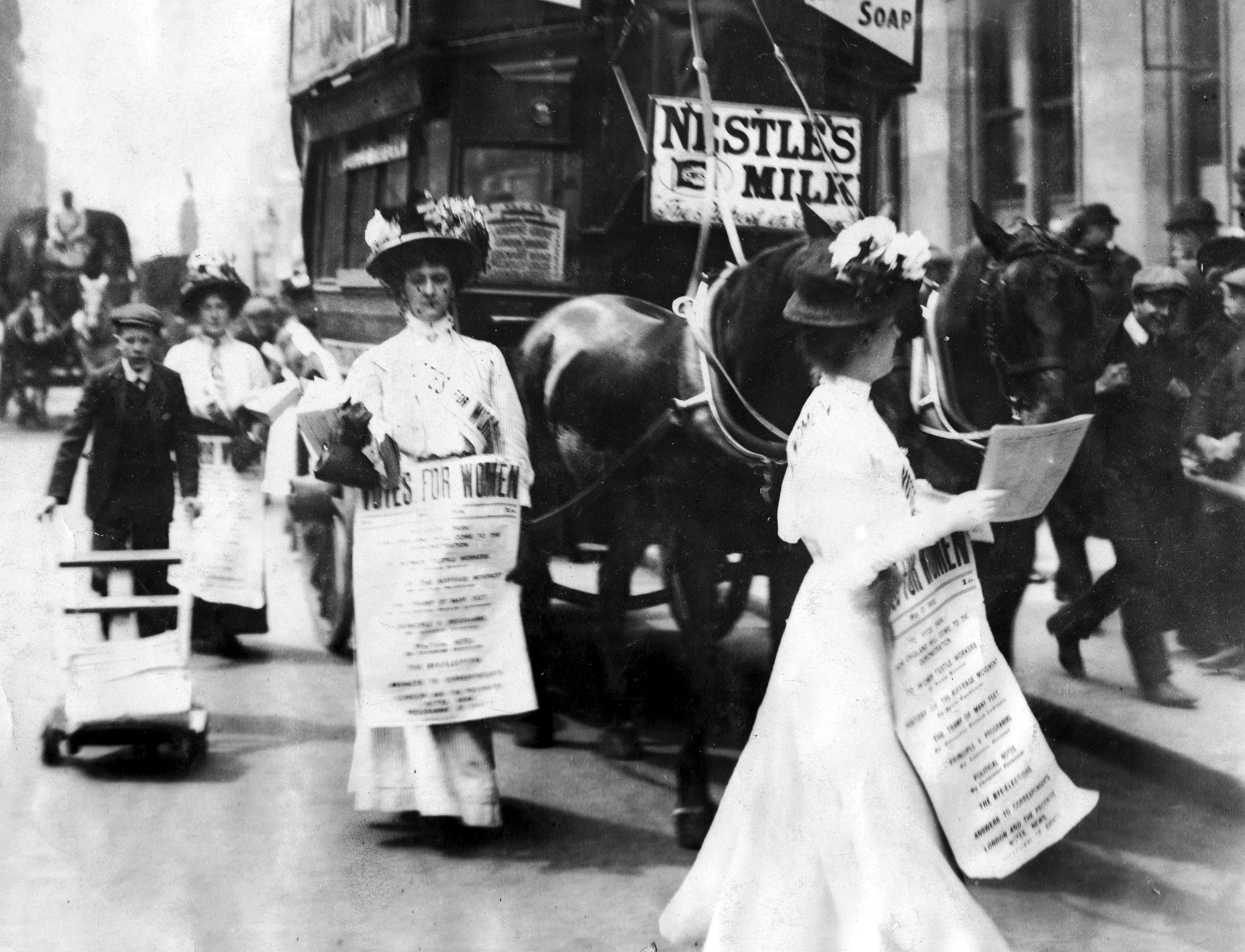 Image of women marching in London, 1908, with signs advocating for women’s right to vote.